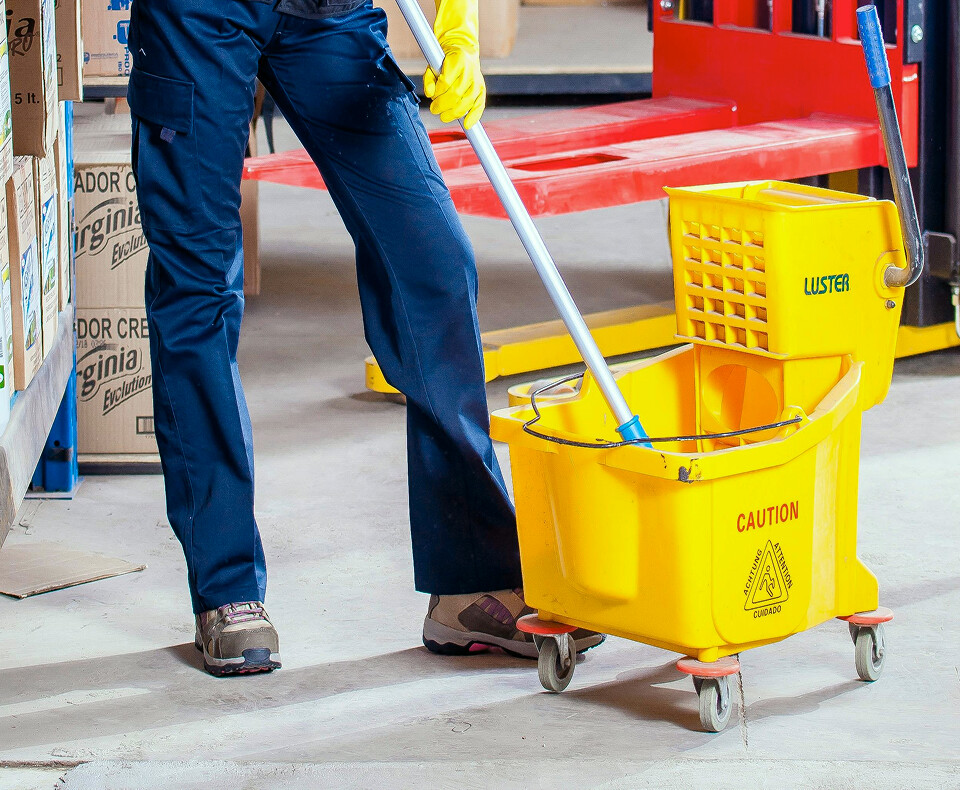 Janitorial service worker with yellow mop bucket